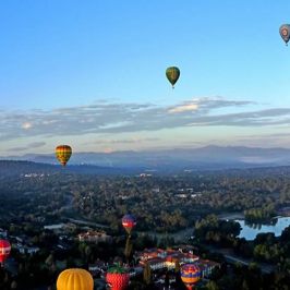 a group of people flying kites in a body of water