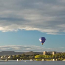 a person flying a kite in a large body of water