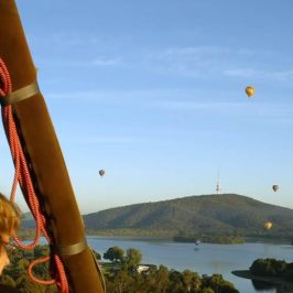 a group of people flying kites in a body of water